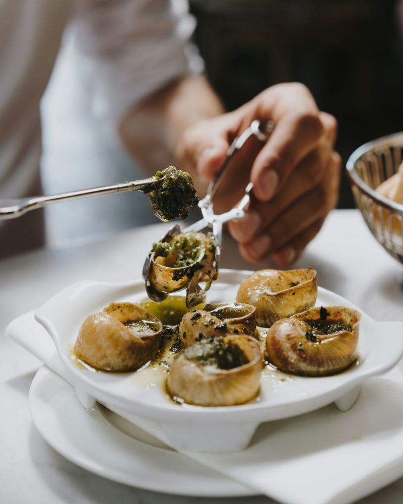 A starter of escargots being served at the table