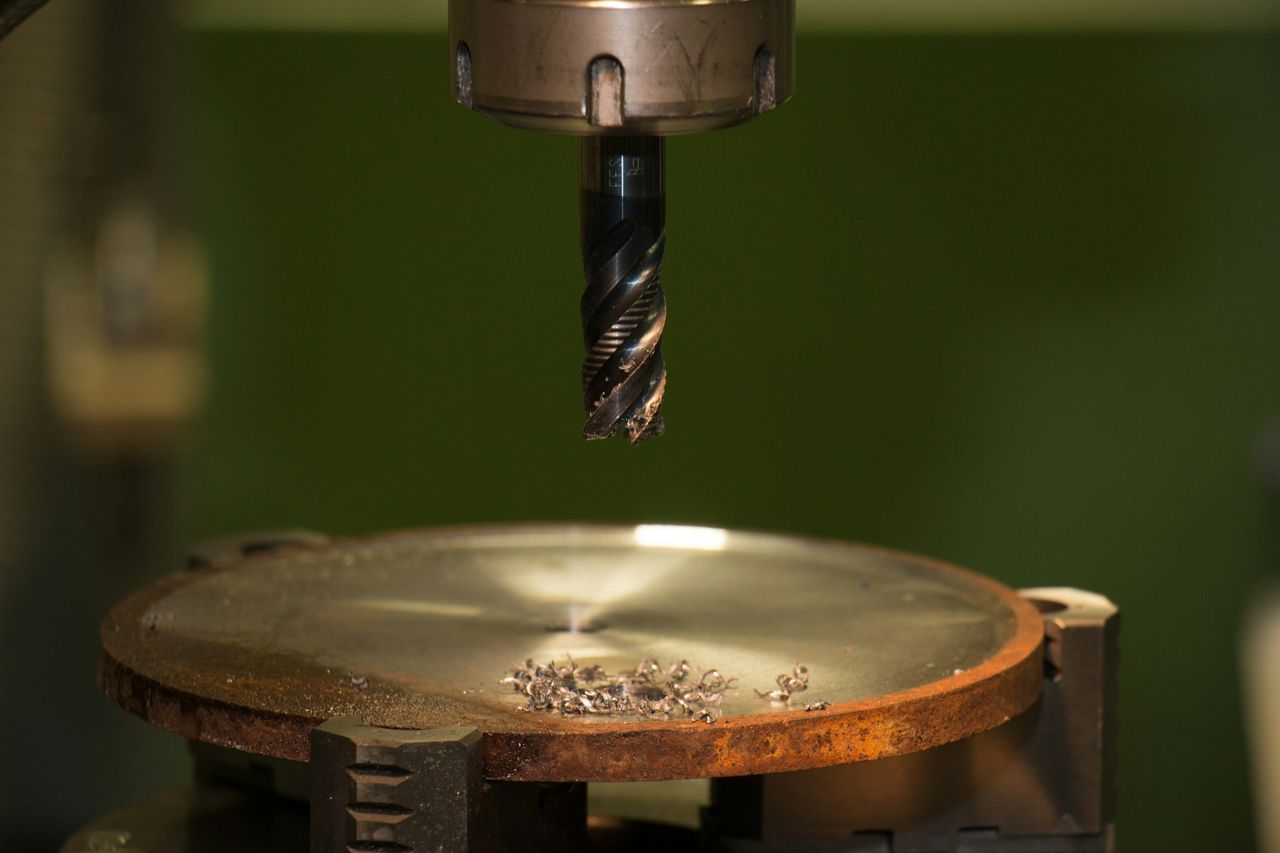 A machining tool positioned above a metal part