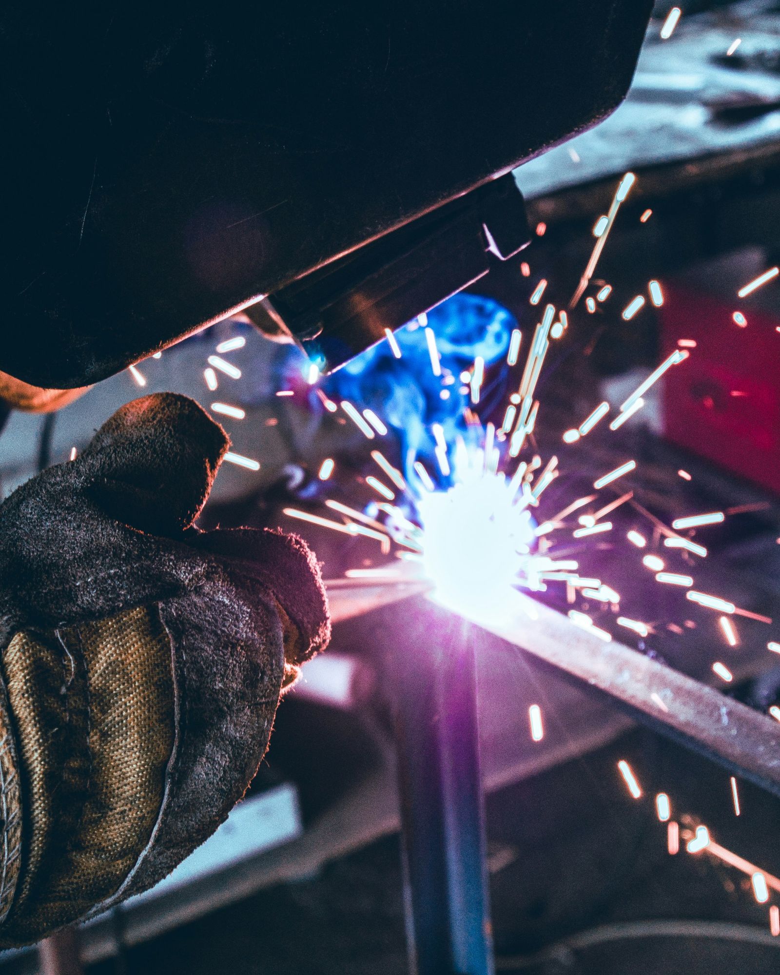 Sparks flying from a welding torch on a steel part