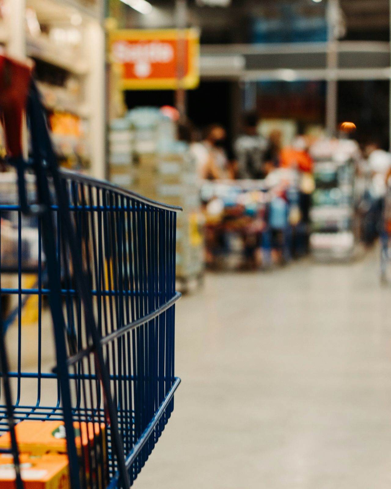 A shopping cart in a store, the aisles softly out of focus